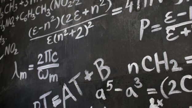 Close-up view of a blackboard filled with complex mathematical equations and formulas.